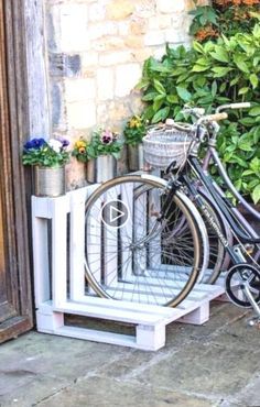 a bicycle is parked next to a planter on the side of a door way