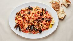 a plate of pasta with mussels and bread