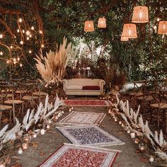 an outdoor seating area with rugs and lights