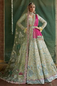 a woman in a white and pink bridal gown standing with her hands on her hips