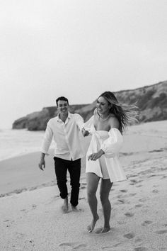 a man and woman are walking on the beach