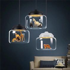 three glass pendant lights with animals in them