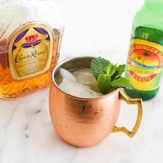 a copper mug filled with ice and mint next to a bottle of ginzetti