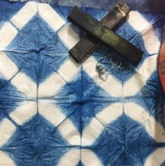 an old pair of scissors sitting on top of a blue and white checkered cloth