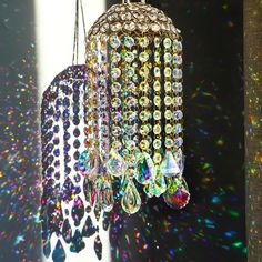 three chandeliers hanging from a ceiling in front of a window covered with multicolored lights