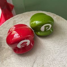 two red and green balls sitting on top of a white table