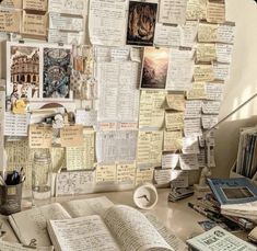 an open book sitting on top of a desk covered in lots of papers and magnets