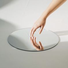 a person reaching for something in the middle of a round table with their hand on it