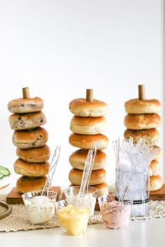 several bagels stacked on top of each other with toppings in front of them