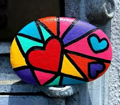 a colorful rock with hearts painted on it