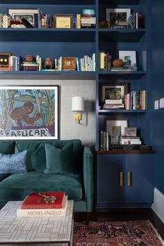 a living room with blue walls and bookshelves on the wall, including a green couch