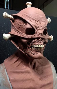 a close up of a statue of a person wearing a helmet with skulls on it