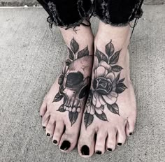 a woman's feet with flowers and a skull tattoo on the bottom of her foot