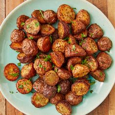 a white plate topped with cooked potatoes on top of a wooden table