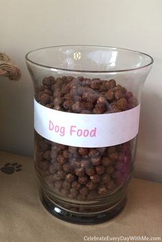 a glass bowl filled with dog food sitting on top of a table next to a stuffed animal