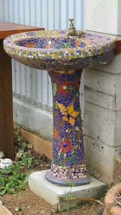 a bird bath sitting on the side of a building