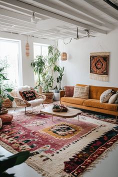 a living room filled with lots of furniture and plants on top of the rugs