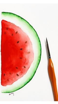 a watermelon cut in half with a paintbrush next to it