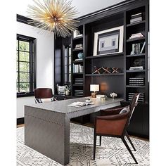 an office with black bookcases, leather chairs and a large table in the center