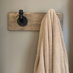 a towel is hanging on a coat rack with a hook in the corner and a light fixture above it