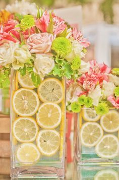 three vases filled with lemon slices and flowers