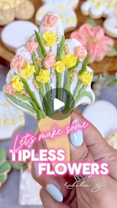 a person holding up a fake flower in front of cookies on a table with words that read, let's make some tipless flowers