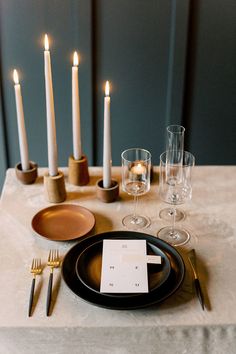 a table set with candles and place settings