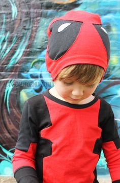 a young boy wearing a red and black costume