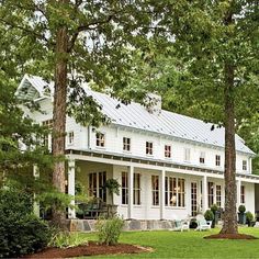 a large white house surrounded by trees and grass