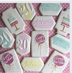 decorated cookies are arranged on a pink and white table