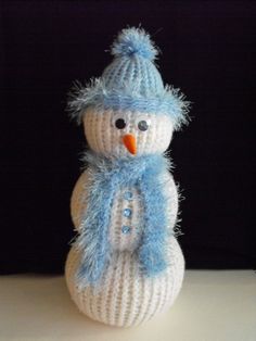 a knitted snowman sitting on top of a table