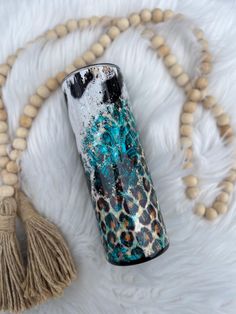 a blue and black vase sitting on top of a white fur rug next to a tassel