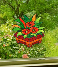 a potted plant sitting on top of a window sill in front of trees