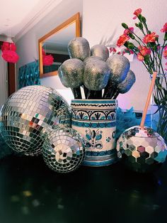 disco balls and flowers in a vase on a table