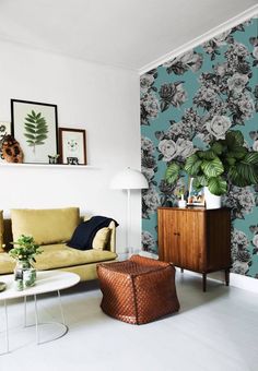 a living room with green walls and white flooring is pictured in this image, there are plants on the wall