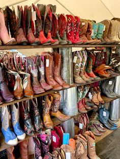 many pairs of boots are lined up on shelves