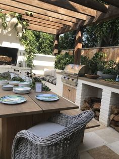 a table with plates on it in front of an outdoor grill and fire pit area