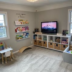 a child's playroom with toys and bookshelves in front of a flat screen tv