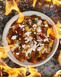 a white bowl filled with food sitting on top of a table covered in fire flames