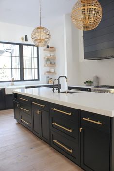 a kitchen with black cabinets and white counter tops