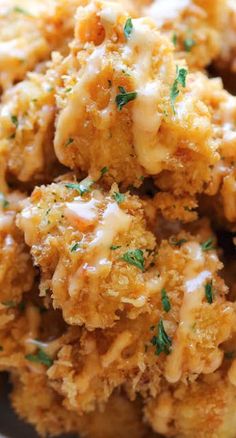 a white bowl filled with fried food on top of a marble countertop and topped with parsley