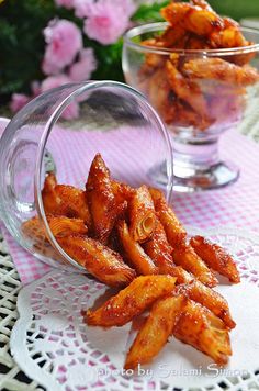 there are some fried food in the glass bowl on the table next to another plate