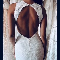 the back of a woman's body wearing a white dress with lacy lace on it