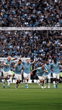 a group of soccer players are running on the field