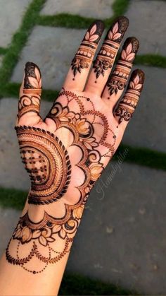 a woman's hand with henna tattoos on it