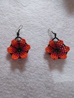 Add to your style with these beautiful handmade flower earrings! Elegant Flower Beaded Earrings, Elegant Orange Flower Earrings For Gift, Red Flower Charm Earrings, Red Flower Earrings With Ear Wire, Drop Earrings With Flower Charm, Elegant Handmade Red Flower Earrings, Elegant Red Handmade Flower Earrings, Unique Flower Charm Dangle Earrings, Handmade Flower-shaped Beaded Earrings As A Gift