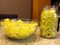 two glass bowls filled with food sitting on top of a counter next to each other