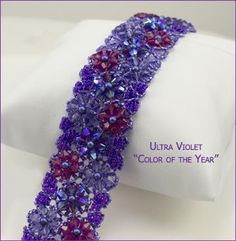 the purple beaded bracelet is on display in front of a white cloth with an inscription that reads ultra violet color of the year