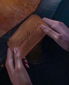 two hands holding a piece of paper with writing on it that says good night next