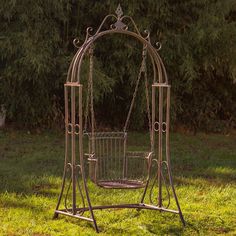 a metal swing with a basket on it in the grass